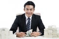 Businessman and two big piles of money on desk Royalty Free Stock Photo