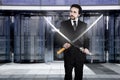 Businessman with two Japanese swords at the entrance of an office building Royalty Free Stock Photo