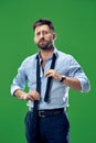 Businessman tying his tie at green studio Royalty Free Stock Photo