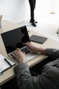 The businessman while typing an information on laptop with office accesssories setting on wood table. /Business and technology con