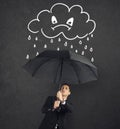 Businessman with umbrella and a angry cloud with rain. Concept of crisis and financial trouble Royalty Free Stock Photo