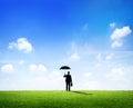 Businessman with Umbrella Standing on a Field Royalty Free Stock Photo