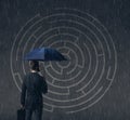 Businessman with umbrella standing over labyrinth background. Bu Royalty Free Stock Photo