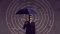 Businessman with umbrella standing over labyrinth background. Bu Royalty Free Stock Photo