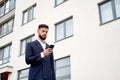 Businessman urban professional business man using mobile phone at office building in city. Professional wearing suit jacket.