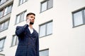 Businessman urban professional business man using mobile phone at office building in city. Professional wearing suit jacket.