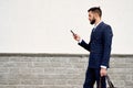 Businessman urban professional business man using mobile phone at office building in city. Professional wearing suit jacket.