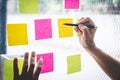 Businessman use post it notes to planning idea and business marketing strategy, Sticky note on glass wall Royalty Free Stock Photo