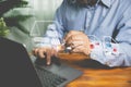 Businessman uses a pen to sign an electronic signature approved on an electronic document with a laptop on a wooden table. Royalty Free Stock Photo