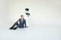 Businessman uses a smartphone while sitting on the floor next to a robot. Modern Robotic Technologies. Humanoid