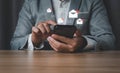 A businessman uses a smartphone to reply to an email.