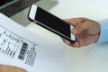 Businessman uses a smartphone to scan the barcode to pay monthly phone bills after receiving an invoice sent to office. Online bil