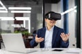 Businessman uses virtual reality glasses VR simulator, inside office at workplace, man in business suit, boss at online Royalty Free Stock Photo