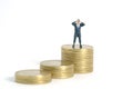 Businessman using binoculars standing above coin money stack. Miniature tiny people toys photography. isolated on white background