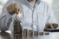 Businessman using calculator and putting coin to saving jar and coins stacking , deposit money saving and business profit growth Royalty Free Stock Photo