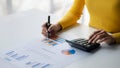 Businessman using a calculator to calculate numbers on a company's financial documents. Royalty Free Stock Photo