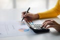 Businessman using a calculator to calculate numbers on a company's financial documents. Royalty Free Stock Photo