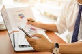 Businessman using cell phone and holding financial graph report on table. Royalty Free Stock Photo