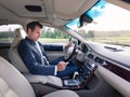 Businessman using cell phone and texting while driving not paying attention to the road. Royalty Free Stock Photo