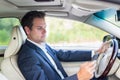 Businessman using cell phone and texting while driving not paying attention to the road. Royalty Free Stock Photo