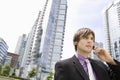 Businessman Using Cellphone Against Buildings Royalty Free Stock Photo