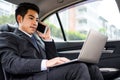 Businessman using computer working car inside. Royalty Free Stock Photo