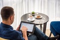 Businessman using digital tablet and drinking coffee. Smartphone Paper Cup Shirt Beard. Office Coffee Break Concept