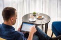 Businessman using digital tablet and drinking coffee. Smartphone Paper Cup Shirt Beard. Office Coffee Break Concept