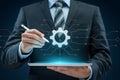 Businessman using digital tablet with gear icon for technology and engineering solutions concept Royalty Free Stock Photo
