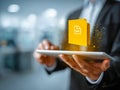 Businessman using digital tablet with glowing yellow document icon representing file sharing, electronic document management, and Royalty Free Stock Photo