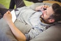 Businessman using digital tablet and mobile phone while relaxing on bean bag at creative office Royalty Free Stock Photo