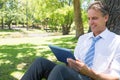 Businessman using digital tablet in park