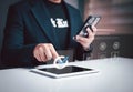 Businessman using digital tablet and smartphone to manage ISO certification documents, quality control, and compliance in smart Royalty Free Stock Photo