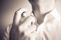 Businessman Using An Eau De Parfum Spray Bottle On His Neck, Monochrome Colors Royalty Free Stock Photo