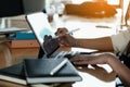 Businessman using electronic pen while working, man hand using stylus pen with tablet while doing financial calculate at Royalty Free Stock Photo