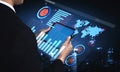 Businessman Using Futuristic Data Visualization Interface with Charts and Global Map on a Dark City Background Impute Royalty Free Stock Photo