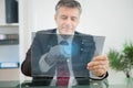 Businessman using futuristic touchscreen to view data