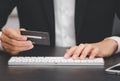 The businessman is using a hand typing keyboard and uses a modern credit card by laptop or smartphone. Royalty Free Stock Photo