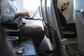 Businessman using laptop in airplane and passenger in front row with cellphone Royalty Free Stock Photo