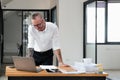 Businessman using laptop computer in office. Happy middle aged man, entrepreneur, small business owner working online. Royalty Free Stock Photo