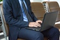 Businessman using laptop computer while sitting on the chair at the airport Royalty Free Stock Photo