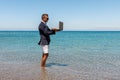 Businessman using laptop computer on tropical beach. Summer vacation concept Royalty Free Stock Photo