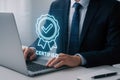 Businessman using laptop with glowing blue certified badge and checkmark icon overlay computer certification Royalty Free Stock Photo