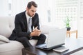 Businessman using laptop on his couch