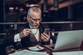 Businessman looking at Phone and drink coffee