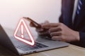 Businessman using laptop showing warning triangle and exclamation sign icon Warning of dangerous problems Server error. Virus. Royalty Free Stock Photo