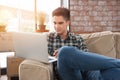 Businessman using laptop on sofa