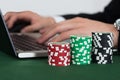 Businessman using laptop by stacked casino chips Royalty Free Stock Photo