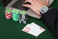 Businessman Using Laptop By Stacked Poker Chips And Cards Royalty Free Stock Photo