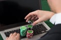 Businessman using laptop with stacked poker chips Royalty Free Stock Photo